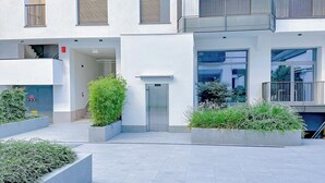 Un edificio moderno con varios balcones, ventanas amplias y una entrada central.