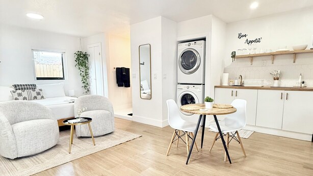 A modern apartment with a living room, a dining area, and a kitchen.