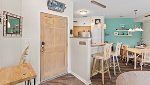 Une cuisine avec des meubles de rangement en bois, un plan de travail et un luminaire suspendu.