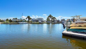 A marina with boats docked, a clear sky, and houses in the background. - 5534 Life of Reilly * Canalfront * Dock (Kill Devil Hills)