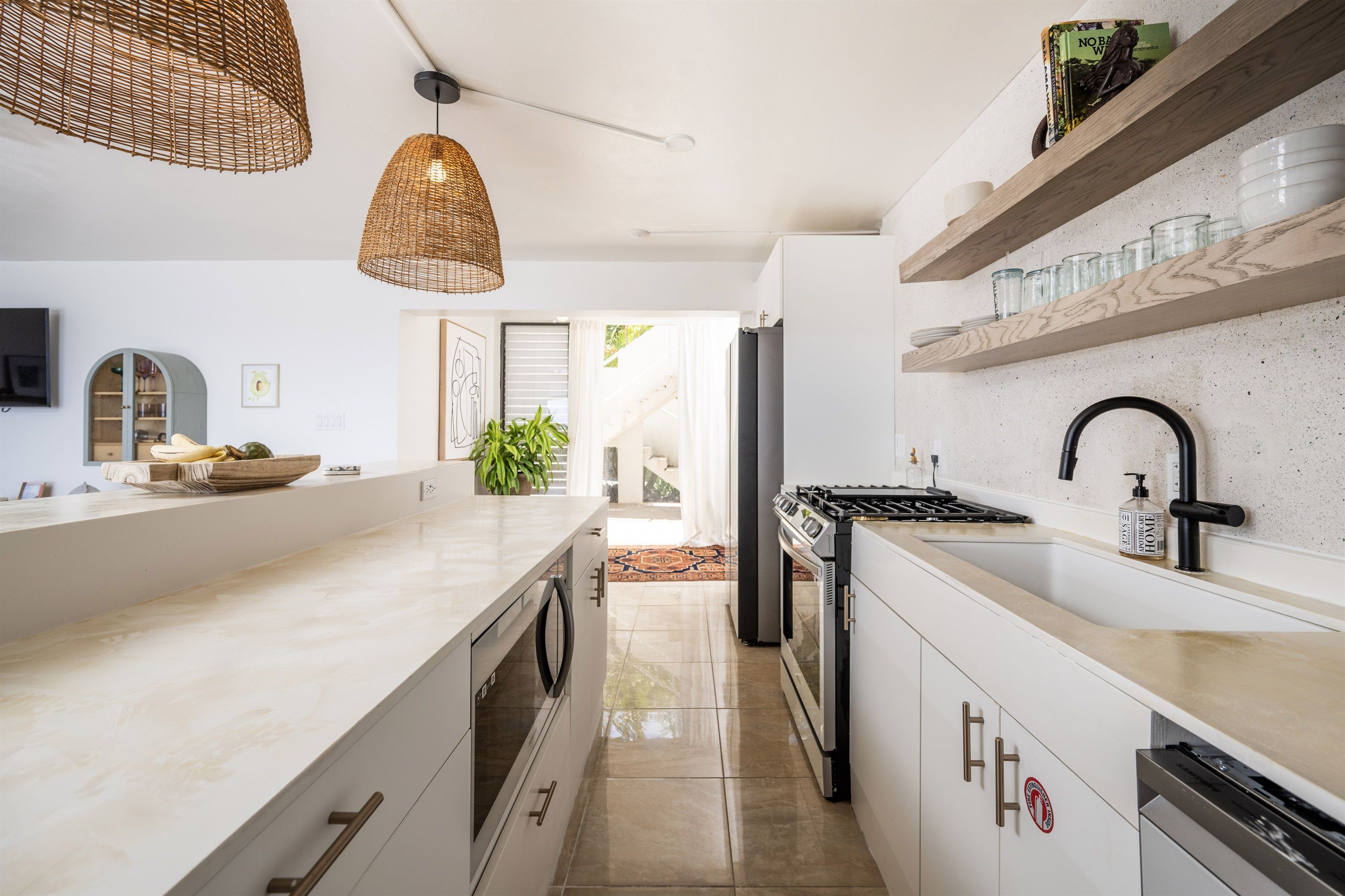 A modern kitchen with a central island, built-in appliances, and wooden shelves.