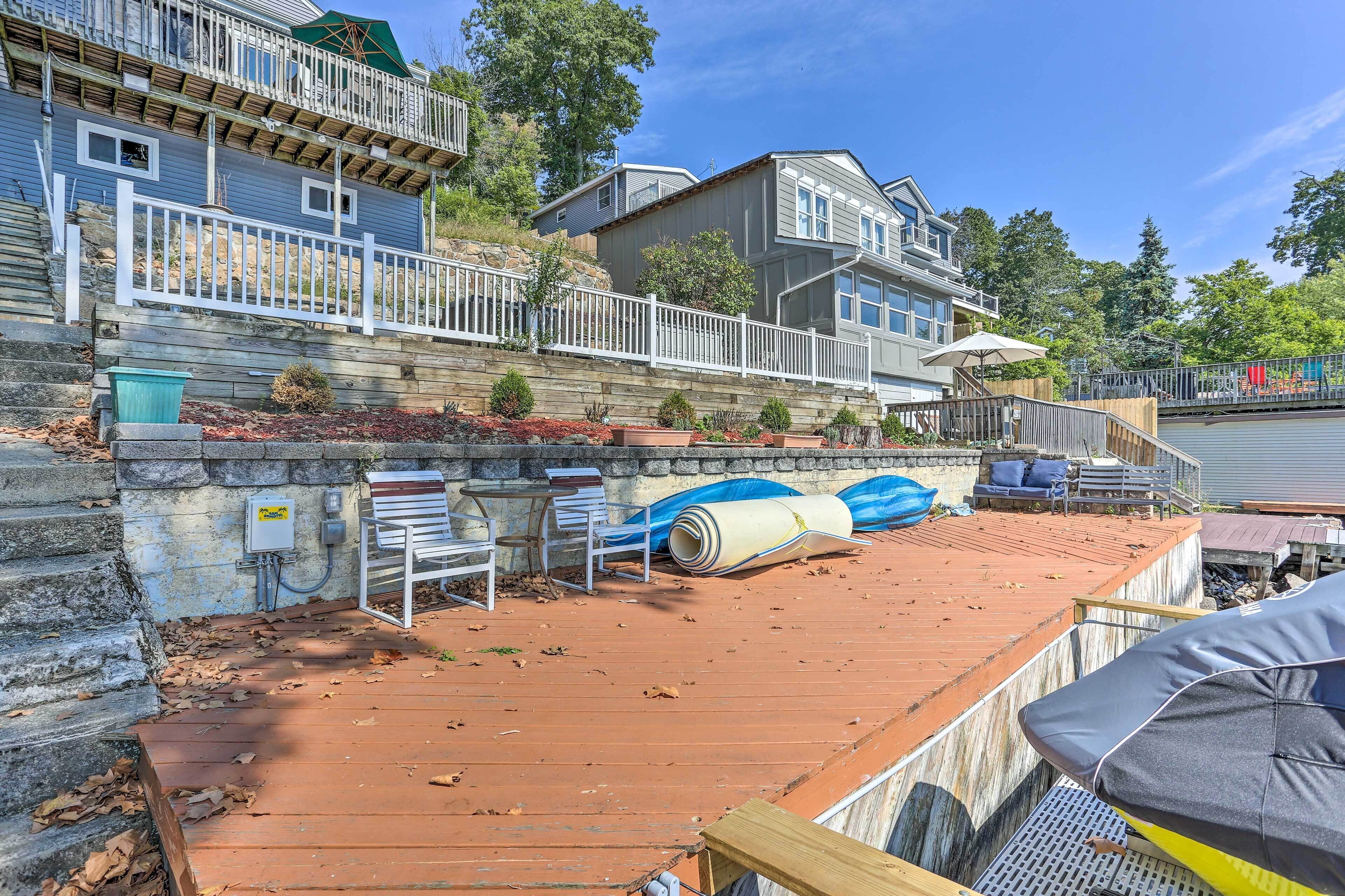 A residential property with a wooden deck, a stone retaining wall, and a small garden area.