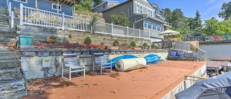 A residential property with a wooden deck, a stone retaining wall, and a small garden area.