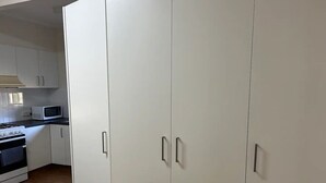 Una cocina con armarios blancos, un microondas y una estufa.