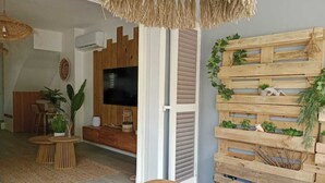 A dining area with a wooden table, chairs, and a woven ceiling light fixture. - Villa Lola in the heart of Baie Orientale, 100m from the beach. 800l tank (Saint martin)
