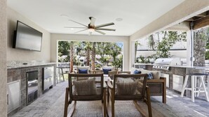An outdoor kitchen area with a dining set, a ceiling fan, and a view of the outdoors. - 221 Cordillo at S Forest Beach, New Build, Easy to Beach, Private Pool (Hilton Head Island)