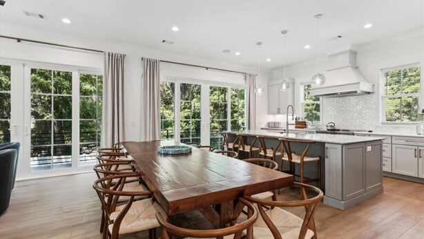 A spacious kitchen with a large island, wooden dining table, and chairs. - 221 Cordillo at S Forest Beach, New Build, Easy to Beach, Private Pool (Hilton Head Island)