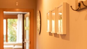 A hallway with framed pictures on the wall and a door leading to another room. - House Llanes (Poo) near the beach - Traudel (Llanes)