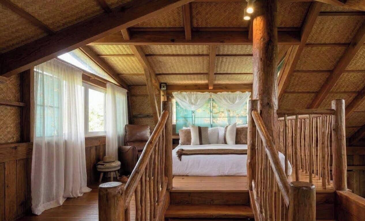 Una habitación rústica de madera con una cama, una silla y una pequeña mesa.