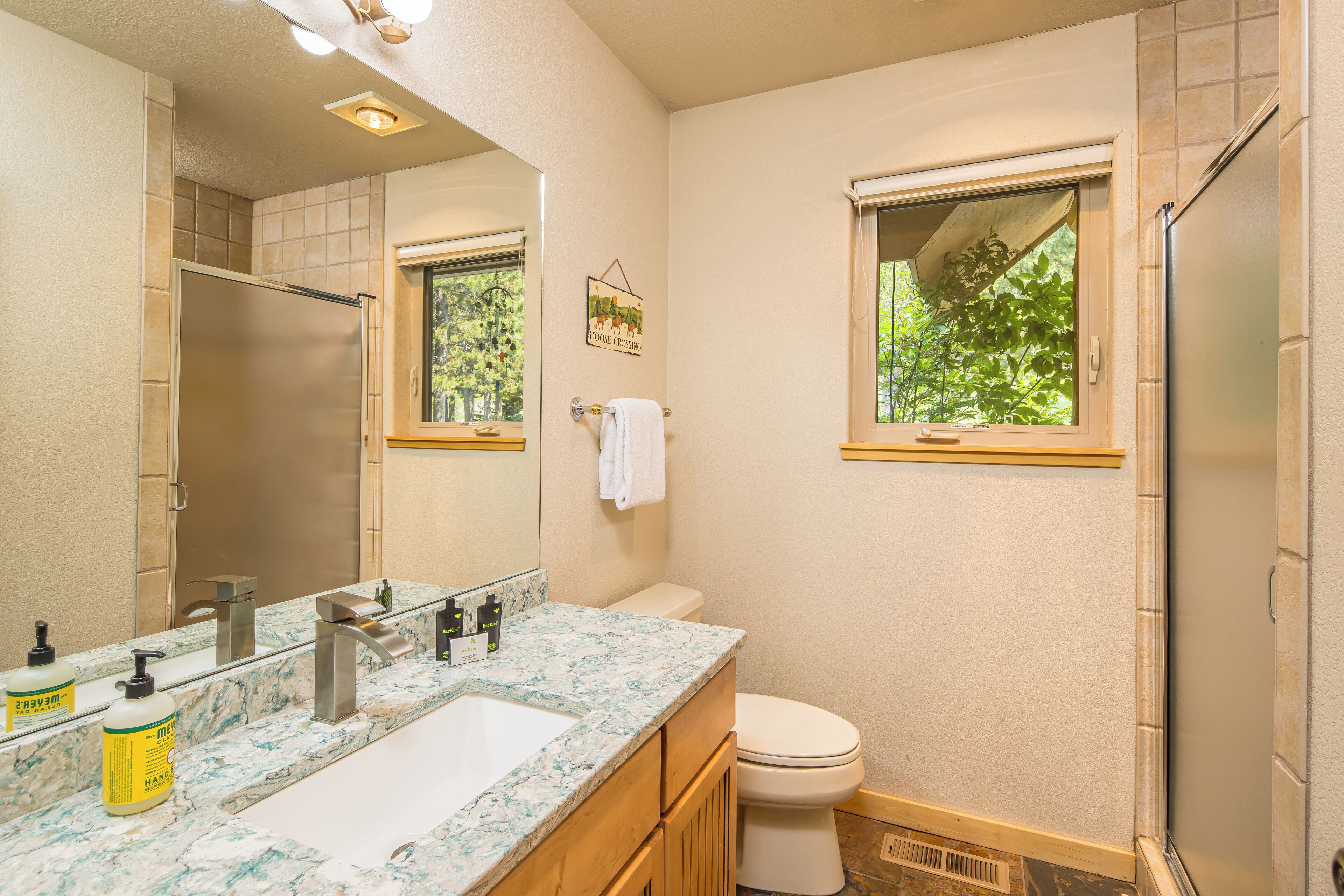 Une salle de bain avec un lavabo en marbre, des toilettes et une douche.