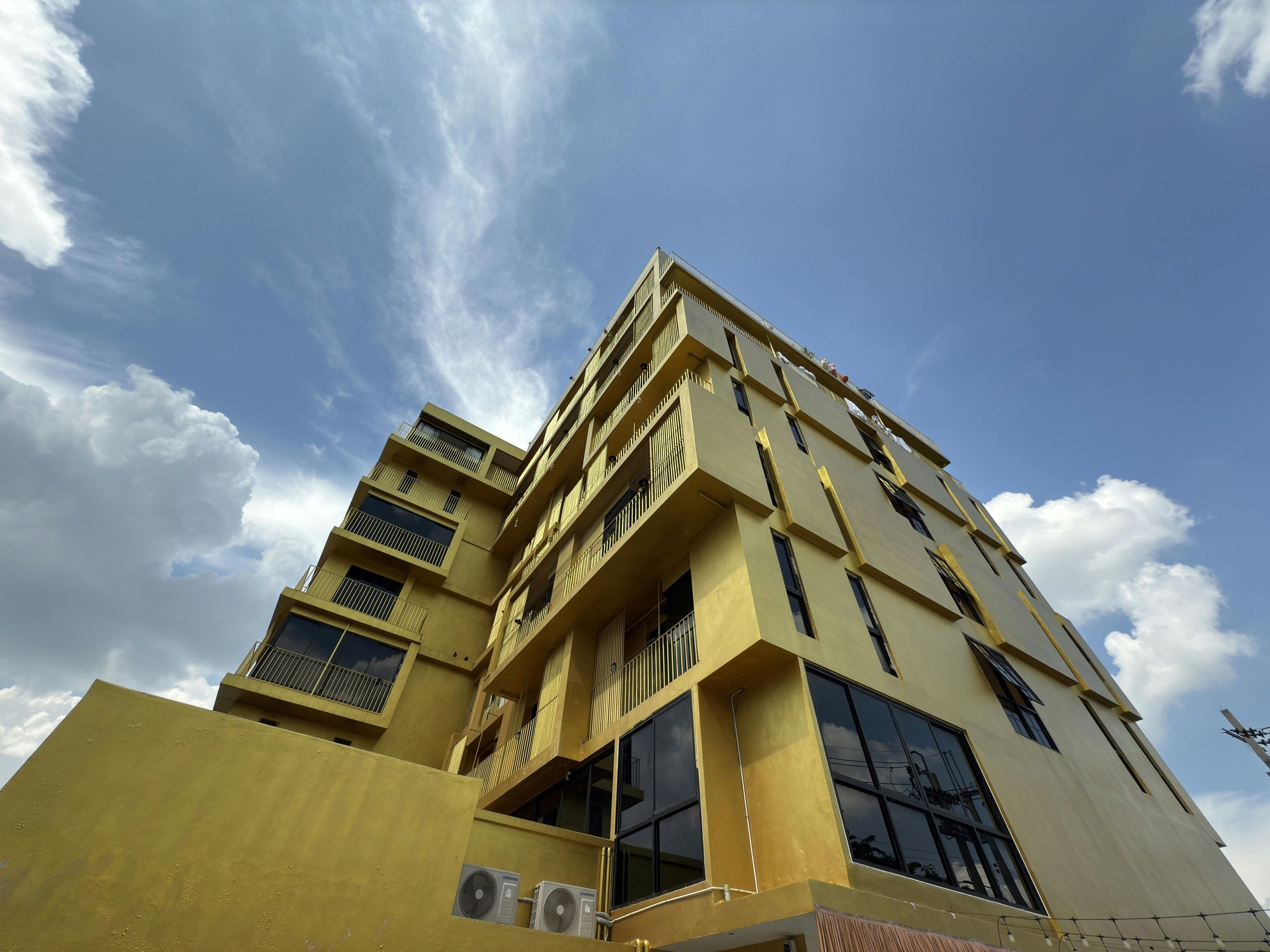 A multi-story building with balconies and large windows, likely a hotel or apartment complex.