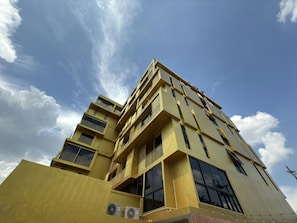 Un edificio de varios pisos con balcones y ventanas grandes, probablemente un hotel o un complejo de apartamentos.