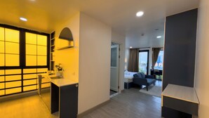 Una habitación de hotel moderna con cocina, un balcón con vistas y un espacio para sentarse.