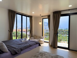 Un dormitorio moderno con una cama grande, vistas a un balcón y un paisaje urbano.