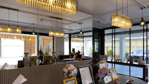 Un área de recepción con mostrador, cuadros enmarcados y jarrones decorativos.