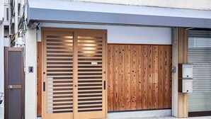 Eine Garage mit Holz-Schiebetür und einem Metallrollladen.