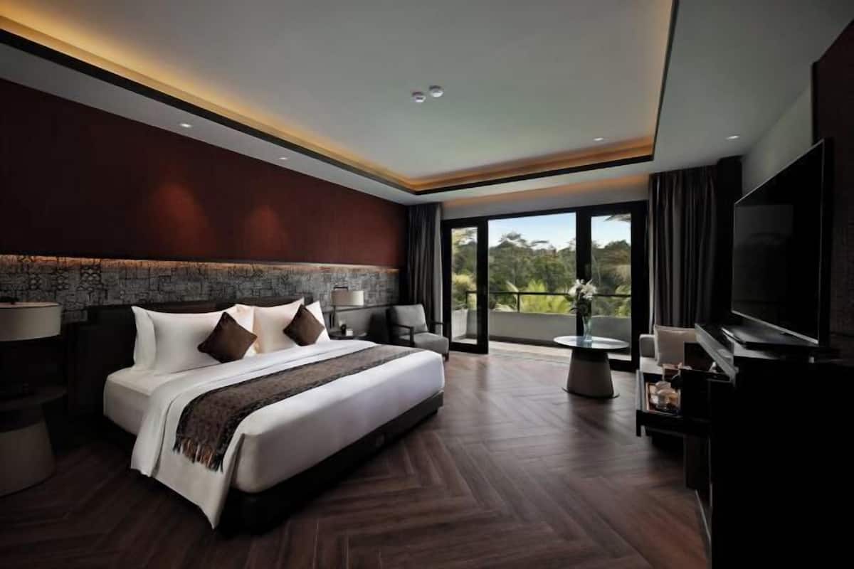 A modern hotel room with a large bed, a flat-screen TV, a balcony with a view, and a dining area.