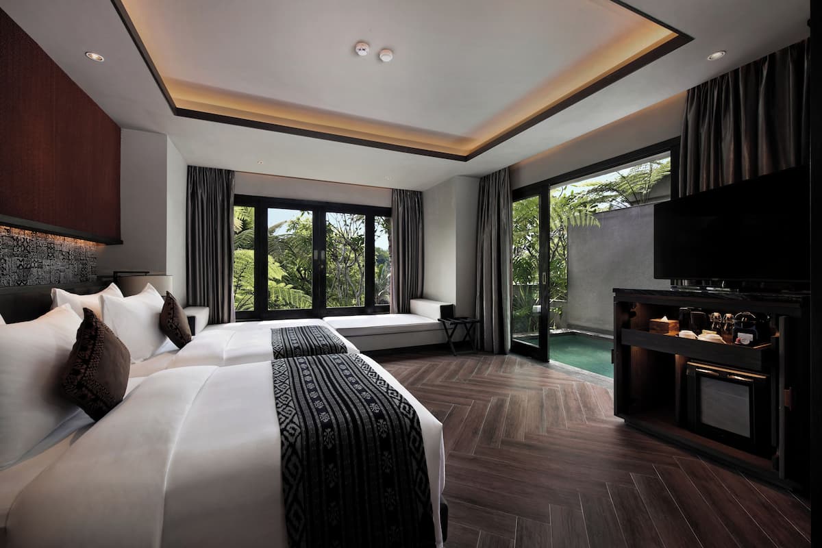 A modern hotel room with a large bed, a TV, and a view of the outdoors.