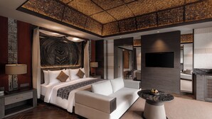 A modern hotel room with a large bed, a sofa, a round coffee table, and a TV. - Ayatara Resort Ubud  (Kerta)