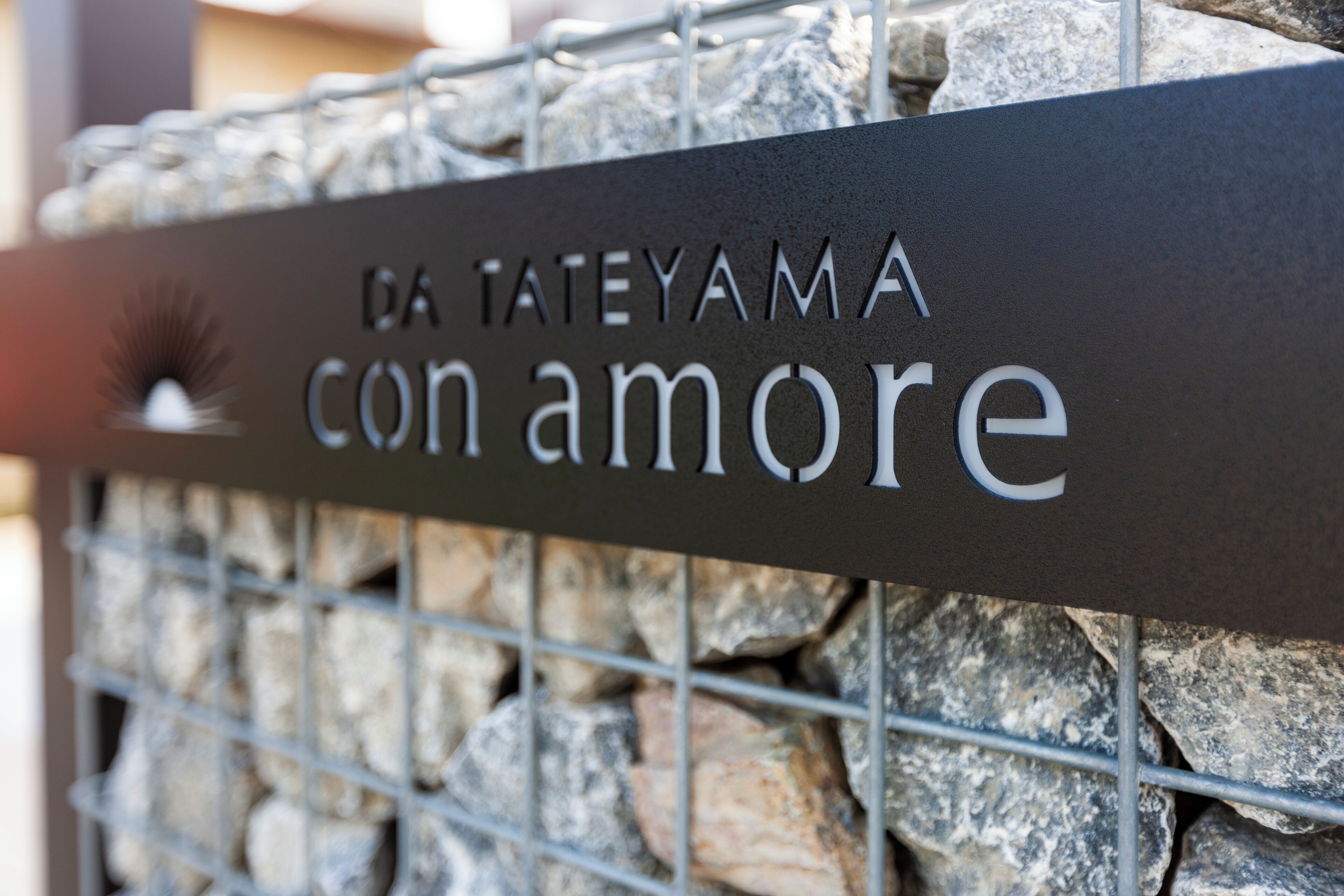 Une pancarte en métal portant l’inscription « DA TATEYAMA con amore ».