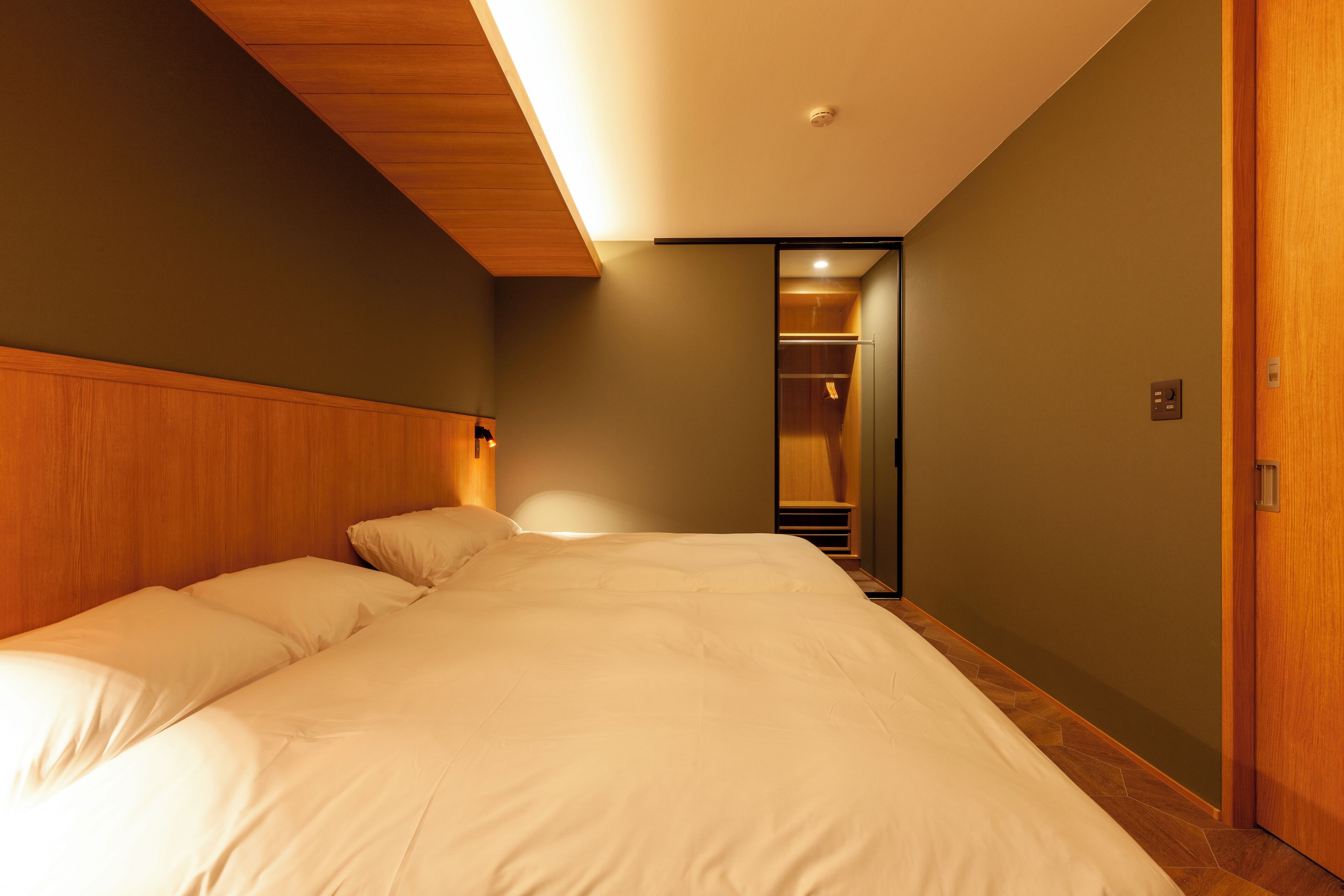 Un dormitorio con una cama grande, cabecera de madera y vestidor.