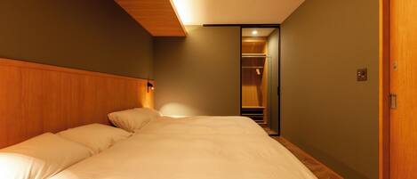 Un dormitorio con una cama grande, cabecera de madera y vestidor.