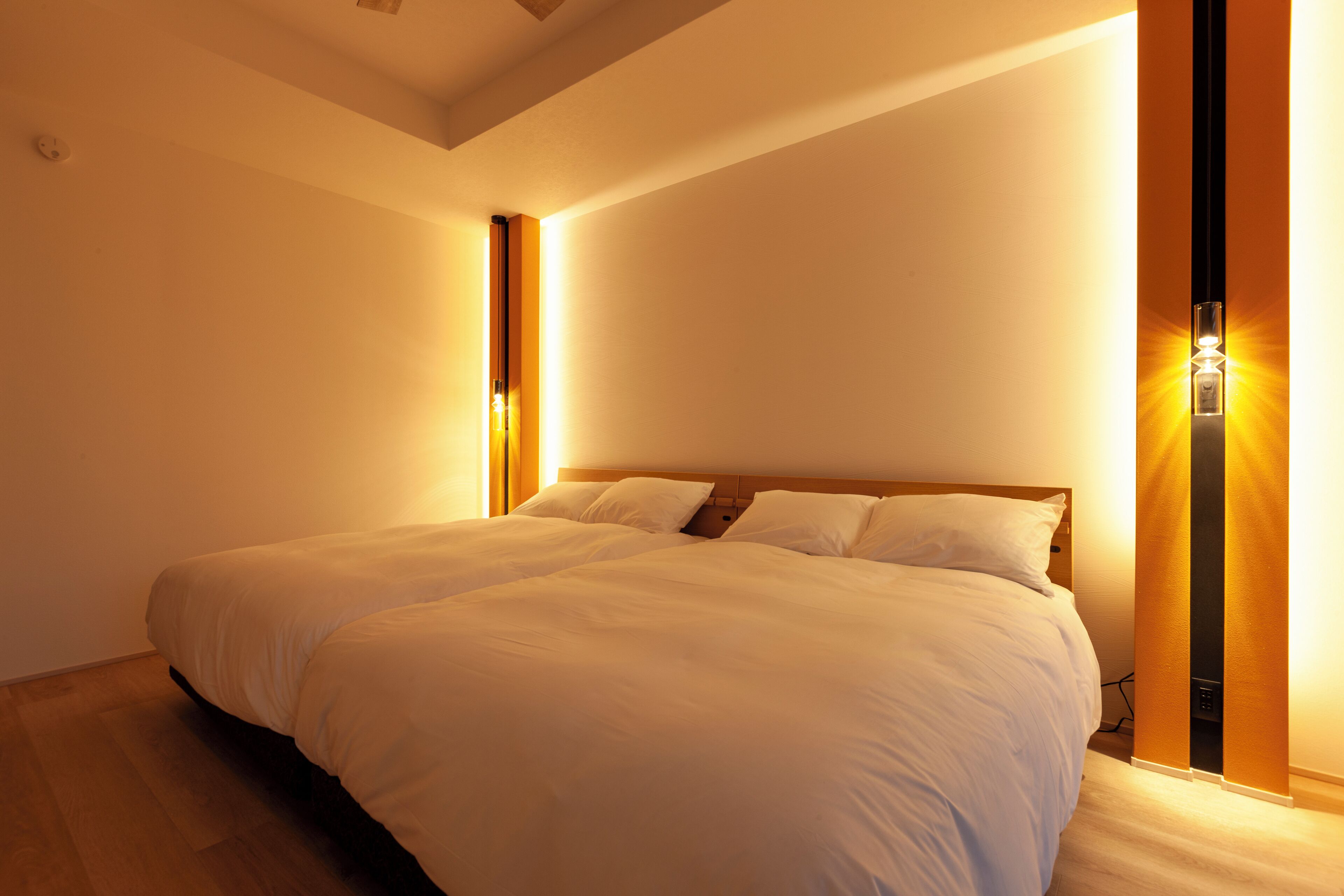 A large bed in a room with a wooden headboard and two wall-mounted light fixtures.