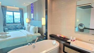 A modern hotel bathroom with a large bathtub, a separate shower area, and a vanity with a mirror.