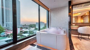 Un baño moderno con una bañera grande, vistas a la ciudad y un diseño minimalista.