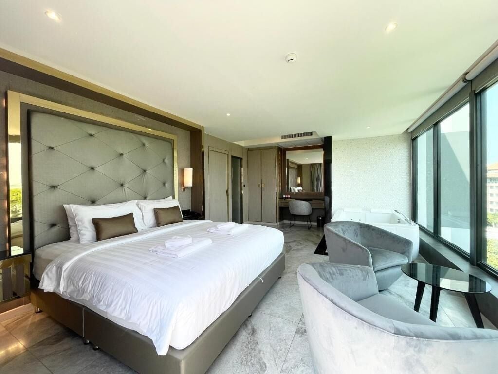 Une chambre d’hôtel moderne dotée d’un grand lit, d’un coin salon et offrant une vue sur la ville.