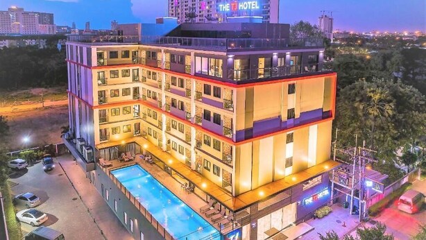 Un hotel de varios pisos con piscina en la azotea y un letrero que dice "The Hotel".