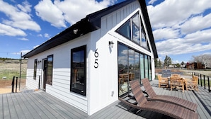 A modern house with a large deck, number 65, featuring a dining area with outdoor furniture. - Bryce, Zion National and State Park Retreat (Hatch)