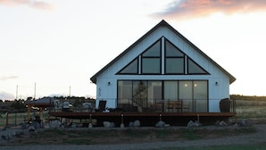 A modern house with a large deck, large windows, and a number '65' on the side. - Bryce, Zion National and State Park Retreat (Hatch)