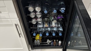 A kitchen with a built-in wine cooler containing various bottles. - Beautiful home on Golf Course in gated community centrally located in Phoenix.  (Phoenix)