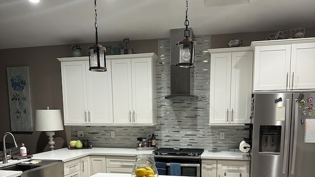A modern kitchen with white cabinets, a central island, and stainless steel appliances. - Beautiful home on Golf Course in gated community centrally located in Phoenix.  (Phoenix)