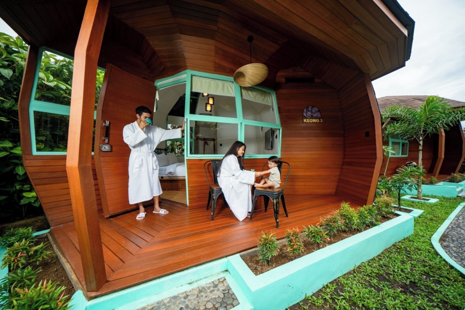 Una cabaña de madera con un porche, un comedor y un pequeño jardín.