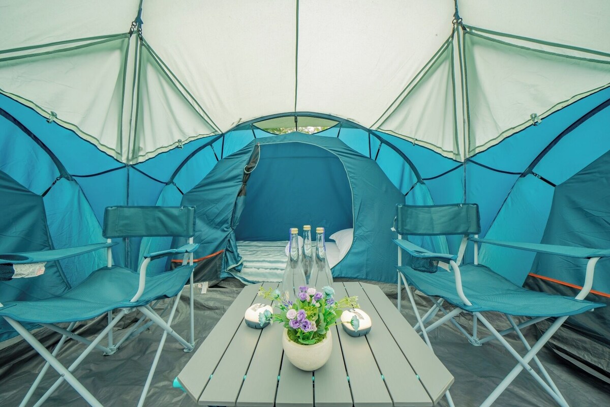 A tent with a table and chairs set up inside.