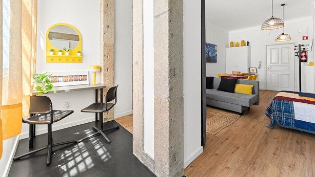 A modern living space with a work area, a sofa, and a bed. - GuestReady - Peaceful home with a private patio (Porto)