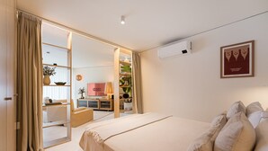 Ein Hotelzimmer mit Bett, Fernseher, Schreibtisch und einem großen Spiegel.