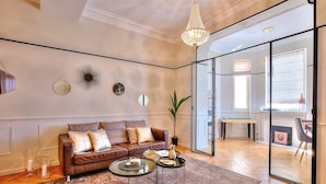 A modern living room with a leather sofa, two coffee tables, and decorative wall art.