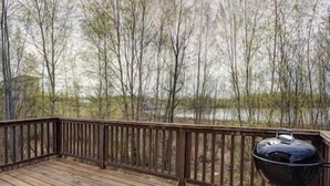 A wooden deck with a barbecue grill. - The Northern Lights Oasis (Wasilla)
