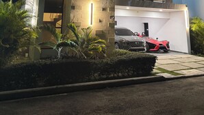 Ein modernes, zweistöckiges Haus mit Garage, Balkon und Auffahrt.