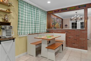 A dining area with a checkered curtain, a coffee machine, and a mural on the wall. - Disneyland Oasis: Heated Pool, Arcade, theater + (Stanton)