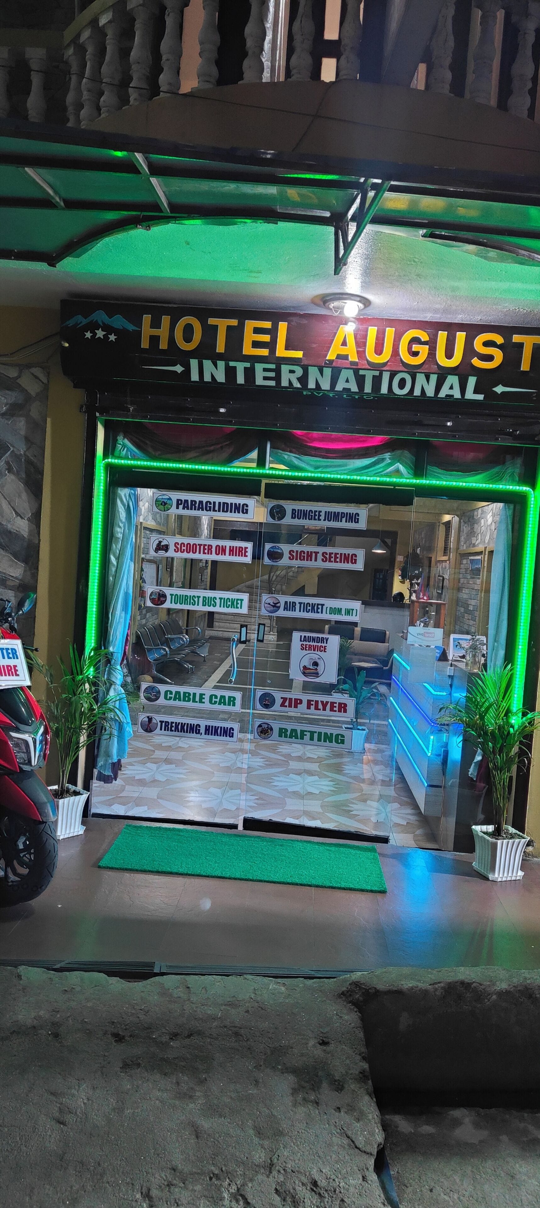 A hotel entrance with signs for paragliding, bungee jumping, and other activities.