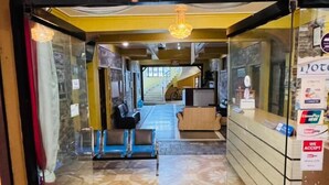 A hotel lobby with a reception desk, seating area, and a staircase leading to upper floors. - Hotel August International (Pokhara)