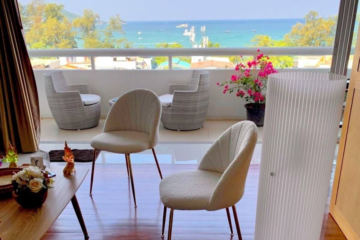Ein Balkon mit Korbstühlen und Blick aufs Meer.