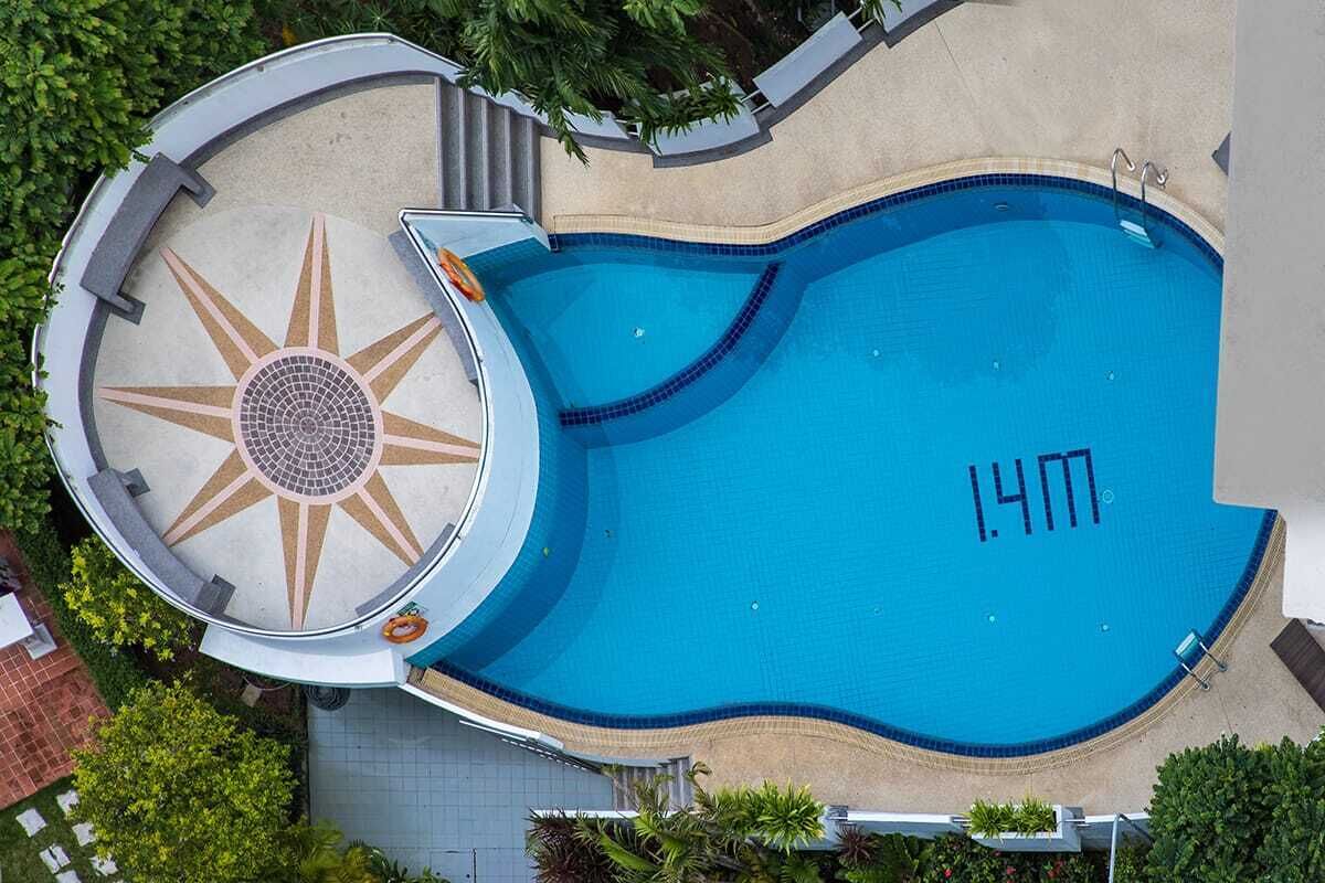 A swimming pool with a sun-shaped design and a depth marker of 1.4 meters.