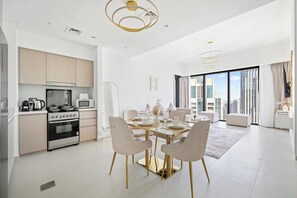 Enjoy a spacious living area with a dining table, kitchen, and city view.