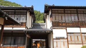 Un bâtiment japonais traditionnel, doté d’une structure en bois, d’un toit recouvert de tuiles et de portes coulissantes.