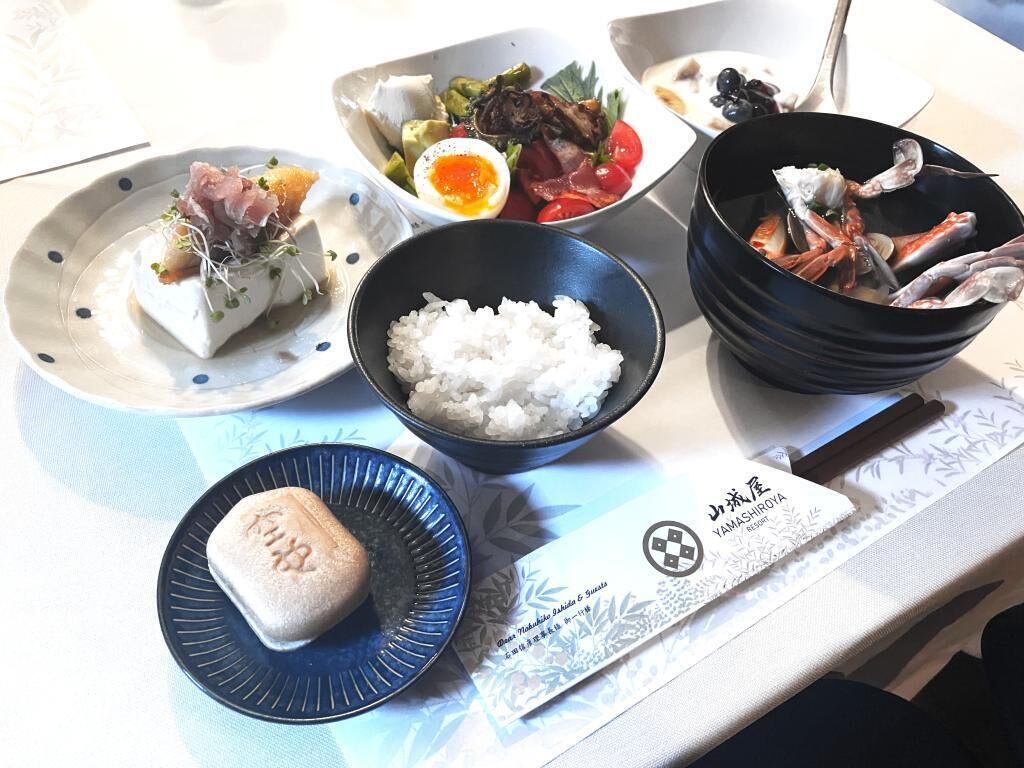 A table with various dishes including rice, seafood, and vegetables.